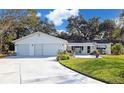 White house with two-car garage and landscaped yard at 10185 Se 175Th Ln, Summerfield, FL 34491