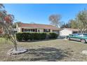 Single-story house with hedges and a tree in front at 10962 Sw 80 Ct, Ocala, FL 34481