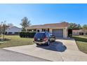 House with driveway and carport, surrounded by green landscaping at 10962 Sw 80 Ct, Ocala, FL 34481