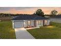 Home's exterior at dusk, showcasing the fresh paint and manicured lawn at 15498 Sw 8 Pl, Ocala, FL 34481