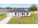 Well-manicured front lawn and simple landscaping accent the home's modern exterior at 15498 Sw 8 Pl, Ocala, FL 34481