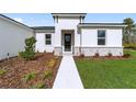 Front walkway leading to a modern entryway with dark gray door and stone accents at 15663 Sw 47Th Avenue Rd, Ocala, FL 34473