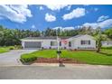 White single story home with American flag and landscaped yard at 17380 Se 98Th Cir, Summerfield, FL 34491