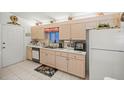 Bright kitchen with light wood cabinets, appliances, and tiled floor at 17380 Se 98Th Cir, Summerfield, FL 34491