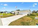 Front view of a house with a driveway and American flag at 17890 Se 96Th Ct, Summerfield, FL 34491