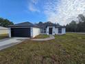 A cozy single-story home featuring a dark roof and a well manicured lawn at 262 Locust Rd, Ocala, FL 34472