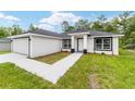 Well-maintained single-story home boasts a two-car garage, neat landscaping, and a freshly painted walkway at 55 Locust Loop Cir, Ocala, FL 34472