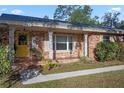 Brick house with a yellow door and decorative columns at 820 Ne 42Nd Ter, Ocala, FL 34470