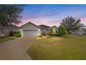 Single-story house with gray siding and a two-car garage, beautifully landscaped at 9211 Sw 66Th Loop, Ocala, FL 34481