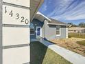 Front entrance with a blue door and walkway at 14320 Se 96Th Ct, Summerfield, FL 34491