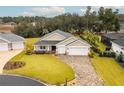 Aerial view of a house, two-car garage, and landscaped yard at 17920 Sw 66Th Pl, Dunnellon, FL 34432