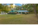 Ranch-style home showcasing a spacious front yard and metal roof at 1981 Se 54Th Ter, Ocala, FL 34480