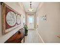 Bright entryway with tiled floor, decorative wall hangings, and a console table at 3165 Hudson Ct, The Villages, FL 32162