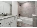 Bathroom with gray tile tub surround and granite countertop at 4482 Sw Clearwater Ct, Dunnellon, FL 34431