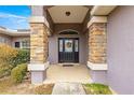 Covered front porch with stone columns and a decorative door at 7 Bahia Circle Loop, Ocala, FL 34472