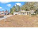 Tan house with white trim, a covered porch, and a spacious yard at 8137 Sw 117Th Loop, Ocala, FL 34481