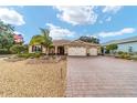 Single-story house featuring a three-car garage and well-manicured landscaping at 9010 Sw 89Th Loop, Ocala, FL 34481