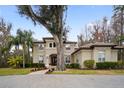 Two-story house with a tile roof, arched entryway and landscaped yard at 1219 Se 46Th St, Ocala, FL 34480