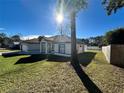 The home's exterior showcases a clean design, a grassy yard, and mature trees at 1846 Ne 127Th Pl, Anthony, FL 32617