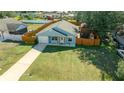 Aerial view of a light blue house with a fenced yard at 21654 Sw Honeysuckle St, Dunnellon, FL 34431