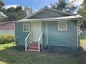 Side view of a charming light blue house with steps leading to the entrance at 2211 Sw 1St St, Ocala, FL 34475