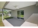 Covered patio with sliding glass door access, ceiling fan and concrete flooring at 46 Locust Pass Run, Ocala, FL 34480