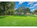 Landscaped yard with a one-story house and lush green grass at 4977 Se 44Th Cir, Ocala, FL 34480