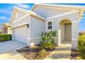 Front view of a house with gray exterior, arched entryway, and landscaping at 5325 Sunshine Dr, Wildwood, FL 34785