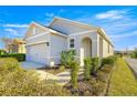 Front view of a single-story house with a gray exterior and landscaping at 5325 Sunshine Dr, Wildwood, FL 34785