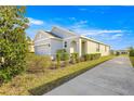 Two-story house with gray siding, two-car garage, and neatly landscaped yard at 5325 Sunshine Dr, Wildwood, FL 34785