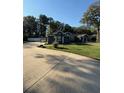 Side view of the house with a paved driveway and landscaped yard at 5579 Se 44Th Cir, Ocala, FL 34480