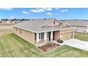 Tan house with gray roof and landscaping, in a residential area at 6158 Sw 88Th Loop, Ocala, FL 34476