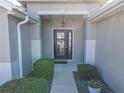 Inviting front entry featuring a covered porch, decorative door, and lush landscaping at 8652 Se 133Rd Ln, Summerfield, FL 34491