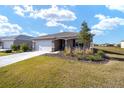 Single story house with white garage door and landscaped yard at 8761 Sw 79Th Loop, Ocala, FL 34481