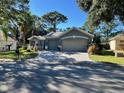 Beautiful gray house with a paved driveway and landscaping at 13300 Se 97Th Terrace Rd, Summerfield, FL 34491