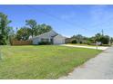 Beautiful single-story house with an expansive green lawn, long driveway, and attached two-car garage at 1664 Sw 167Th St, Ocala, FL 34473