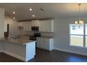 Modern kitchen with white cabinets, stainless steel appliances, and a granite countertop island at 2142 Nw 23Rd Loop, Ocala, FL 34475