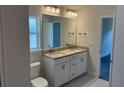 Bathroom with double sink vanity, granite countertop, and large mirror at 2146 Nw 23Rd Loop, Ocala, FL 34475