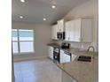 Bright kitchen with stainless steel appliances, granite countertops, and white cabinets at 2146 Nw 23Rd Loop, Ocala, FL 34475
