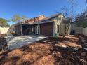 The screened-in patio overlooks the mulched backyard with a small tree and a vintage wheel decoration at 4542 Ne 4Th St, Ocala, FL 34470