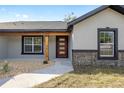 Modern home's front entrance with red door and wood accents at 61 Water Track Loop, Ocala, FL 34472