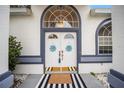 Close up of the front double doors showing wreath details, a striking door mat, and ornate lighting fixture at 7528 Sw 102Nd Loop, Ocala, FL 34476