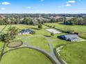 Aerial view showing the home, barn, and riding arena on the property at 7675 W Highway 326, Ocala, FL 34482