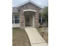 House entrance with stone details and landscaping at 1060 Sw Big Tree Rd, Dunnellon, FL 34431