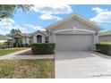 Gray house with a two-car garage and manicured lawn at 12531 Se 90Th Ter, Summerfield, FL 34491