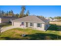 One-story house with a gray roof, light gray siding, and American flag at 13198 Sw 29Th Cir, Ocala, FL 34473