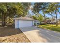 Light blue house with a white garage door and long driveway at 2340 Ne 43Rd St, Ocala, FL 34479