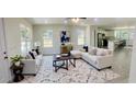 Bright living room featuring contemporary furnishings, large windows, and an open concept kitchen providing ample space at 2881 Se 140Th Pl, Summerfield, FL 34491