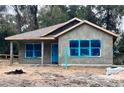 Newly constructed home exterior with gray siding, covered porch, and landscaping at 2998 Se 140Th Ln, Summerfield, FL 34491