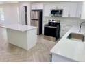 Modern kitchen with stainless steel appliances, quartz countertops, and a kitchen island at 2998 Se 140Th Ln, Summerfield, FL 34491